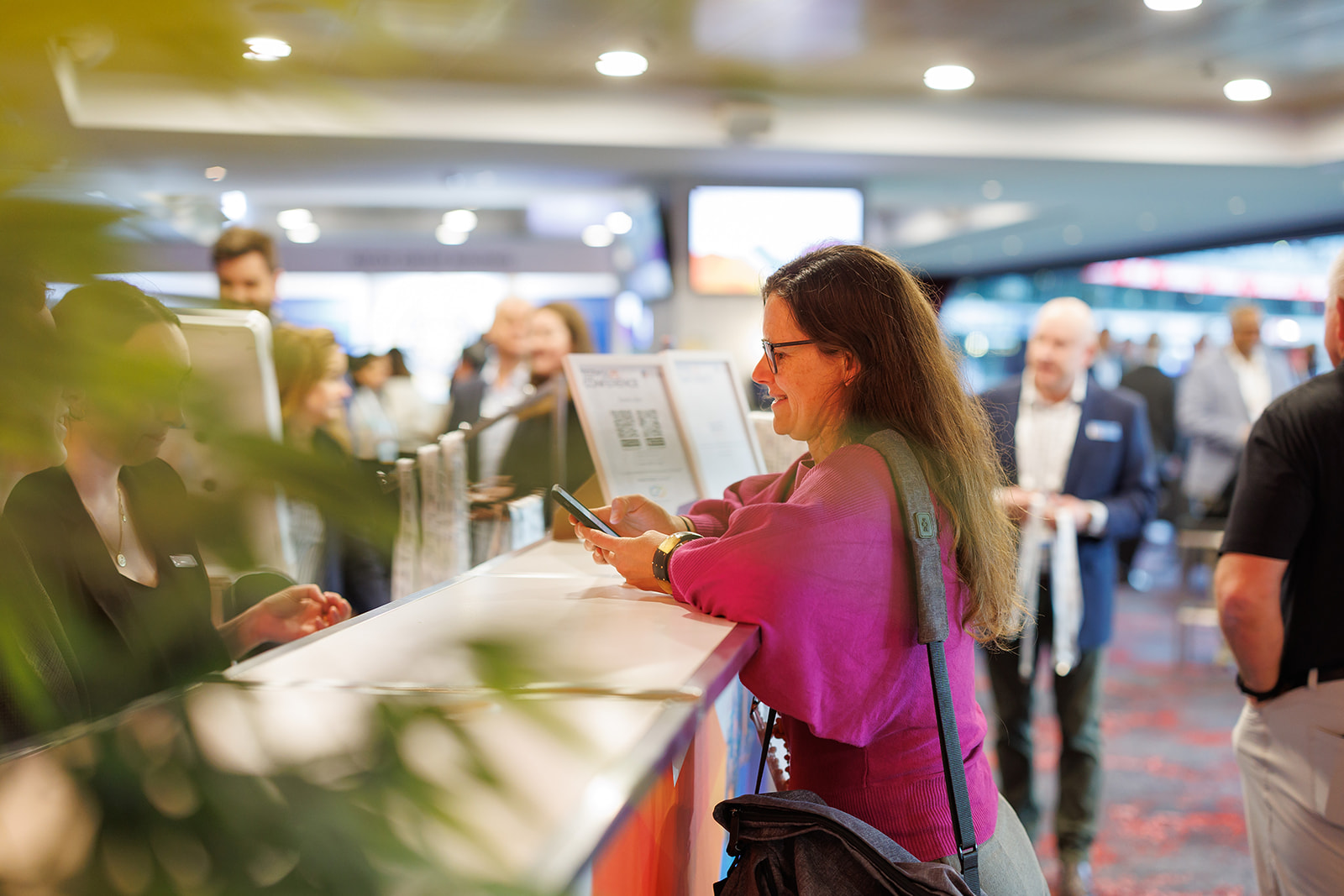 A smiling delegate at the registration counter of a TAS conference
